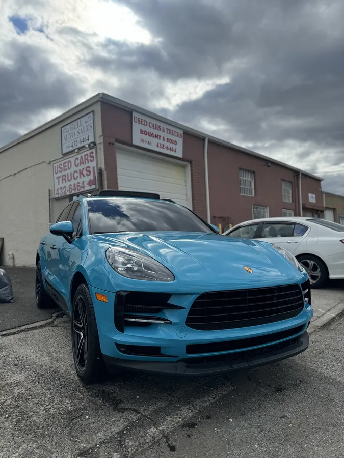 Teal blue Porsche Macan parked in the shop